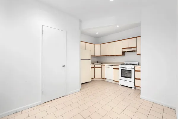 a kitchen with white cabinets and white appliances