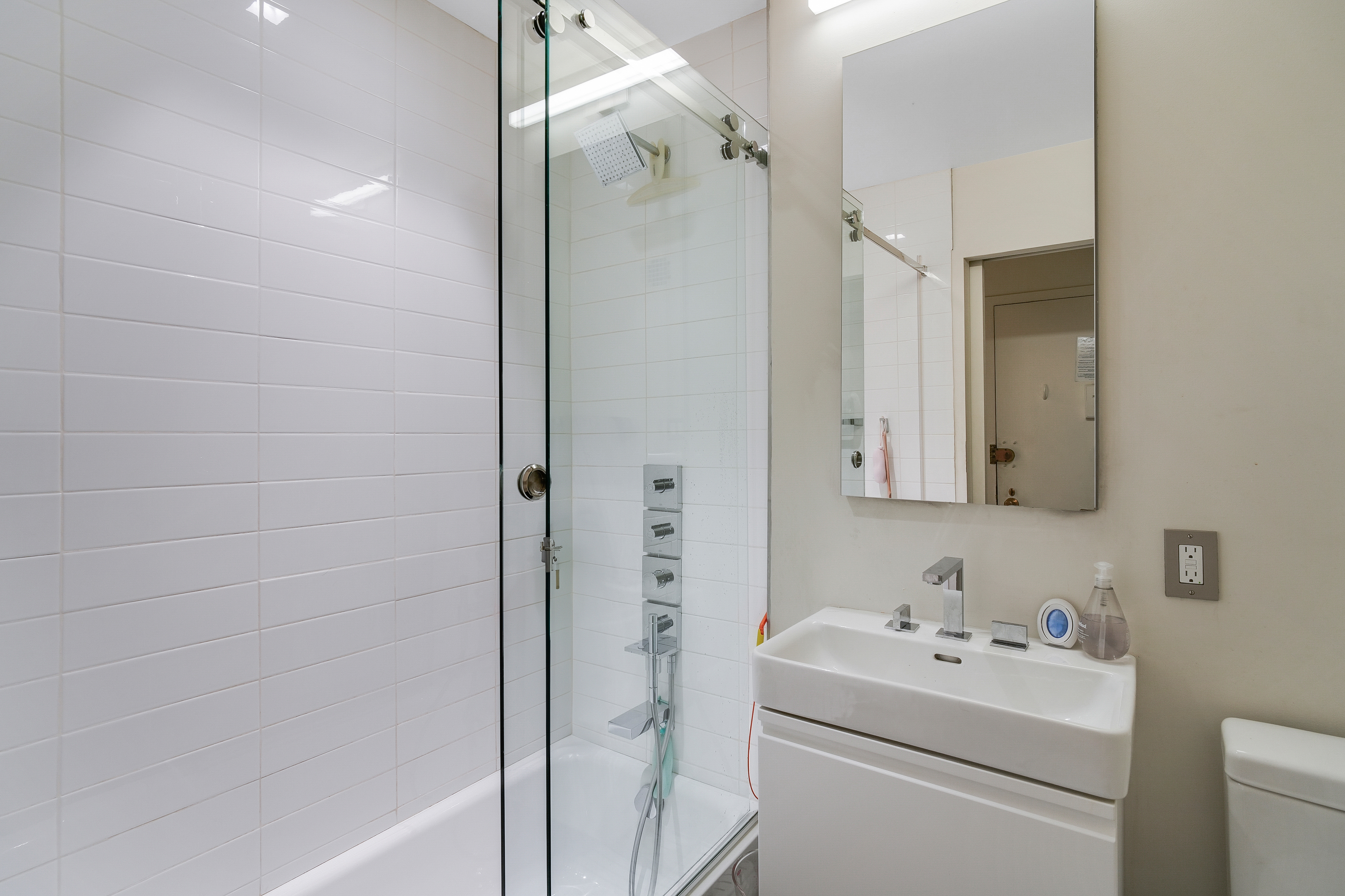 35 East 10th Street, Unit 3G Manhattan, NY 10003 - Photo 5 of 9 a bathroom with a sink a toilet and shower