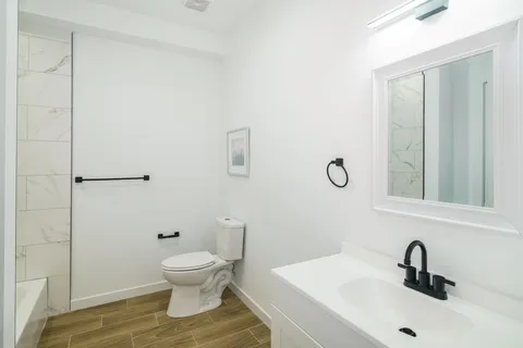 a bathroom with a toilet a sink and mirror