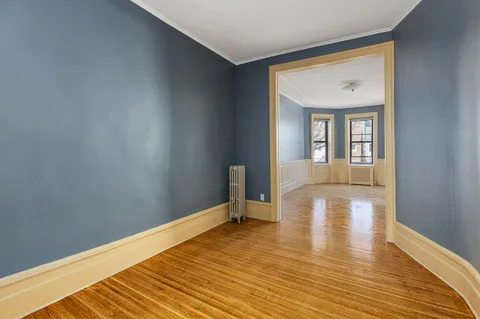a view of a room with wooden floor and furniture