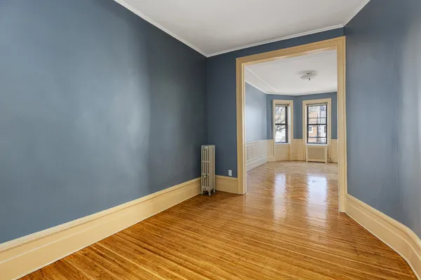 a view of a room with wooden floor and furniture