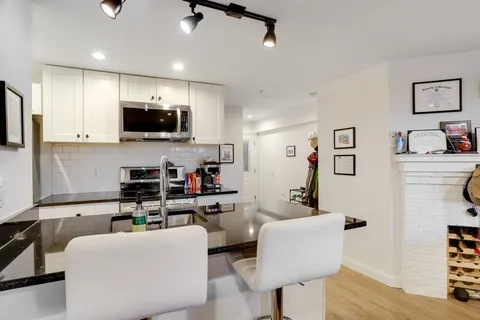 a kitchen with stainless steel appliances a sink a stove and cabinets