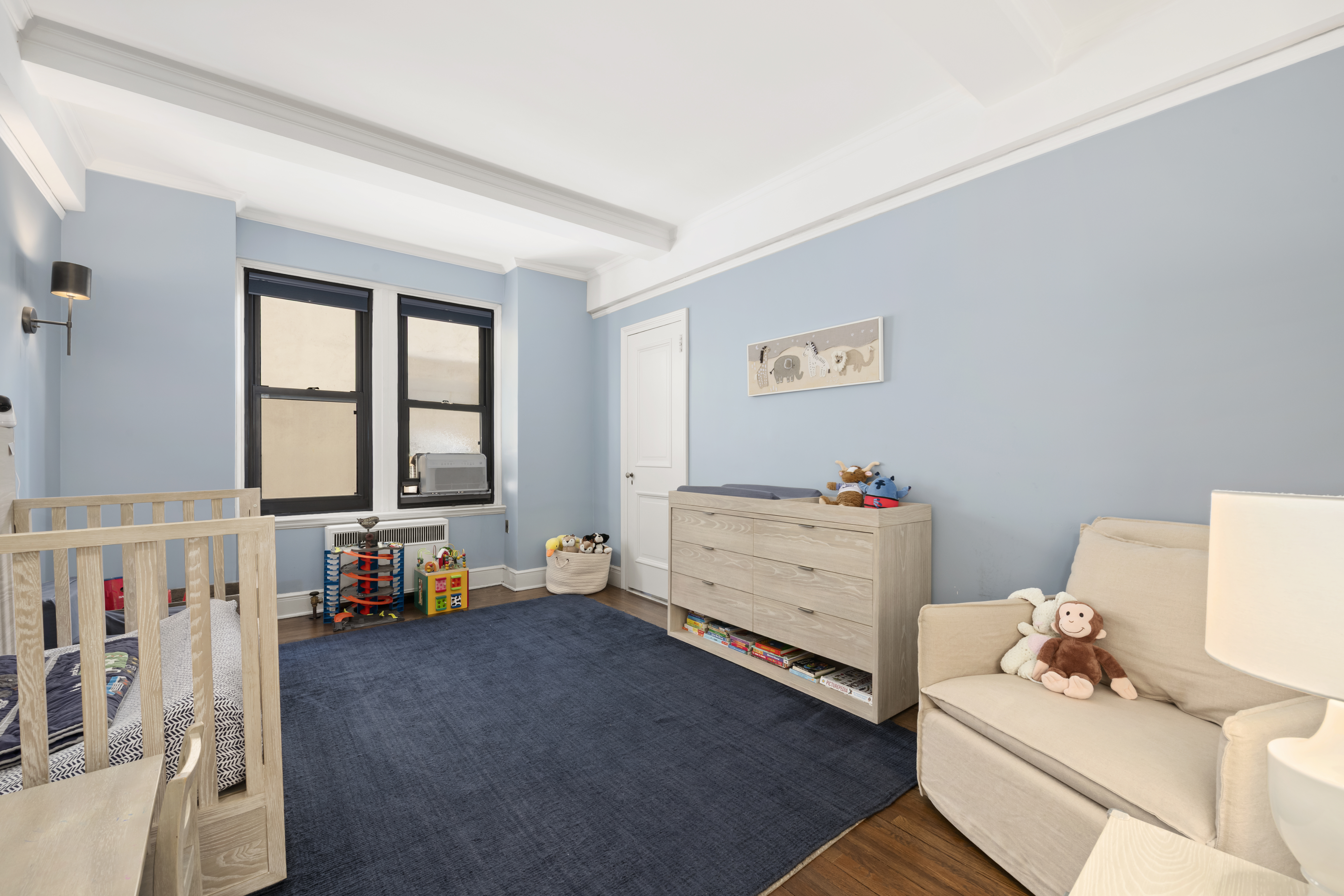 320 East 72nd Street, Unit 6A Manhattan, NY 10021 - Photo 7 of 13 a room with furniture a baby crib and a window