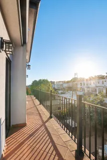 a view of a balcony with wooden floor and fence
