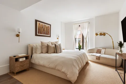 a bedroom with bed couch and window