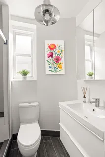 a bathroom with a sink a toilet and a window