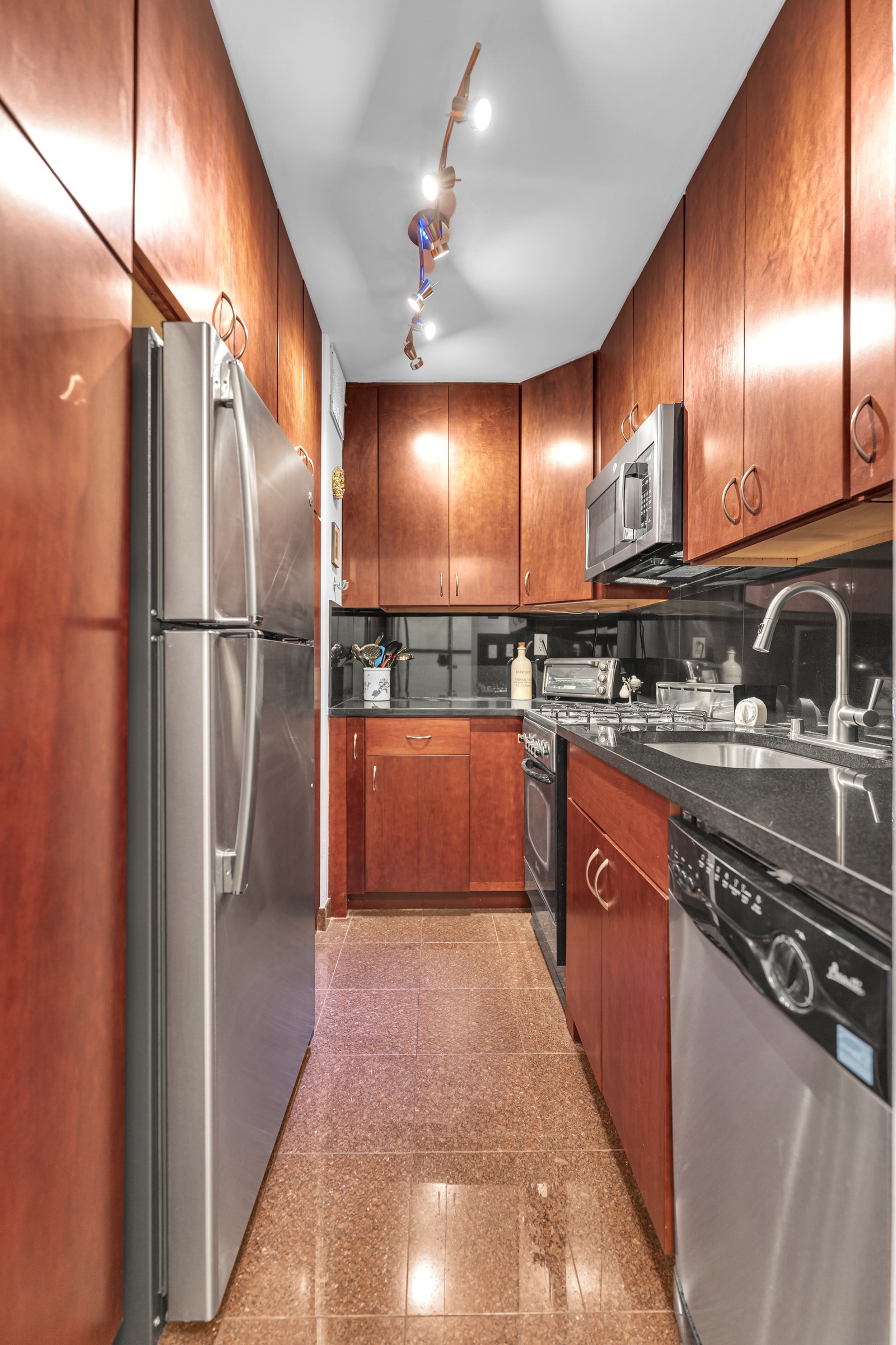 180 West End Avenue, Unit 9P Manhattan, NY 10023 - Photo 2 of 13 a kitchen with stainless steel appliances granite countertop a refrigerator a sink and a stove