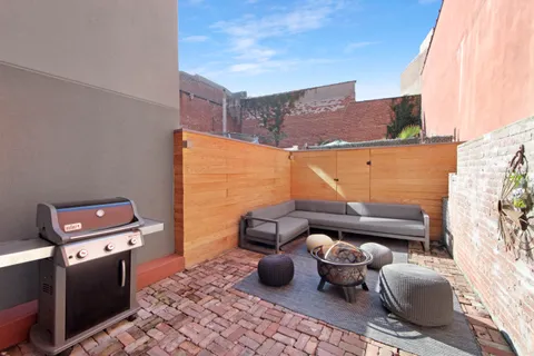 a living room with furniture a flat screen tv and a floor to ceiling window