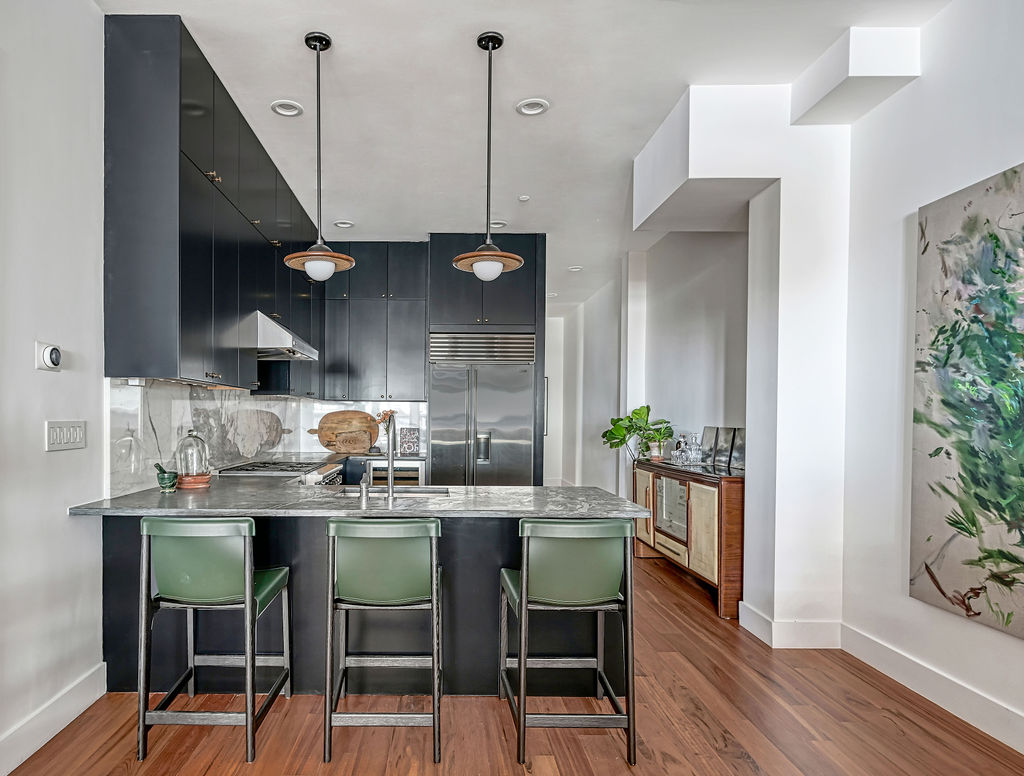 42 East 12th Street, Unit 2 Manhattan, NY 10003 - Photo 17 of 18 a kitchen with stainless steel appliances kitchen island a table and chairs in it