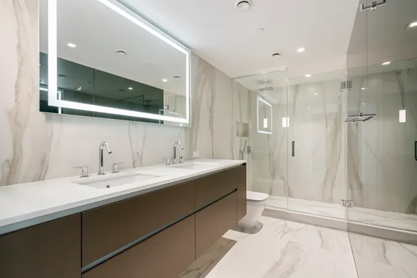 a bathroom with a double vanity sink mirror and shower