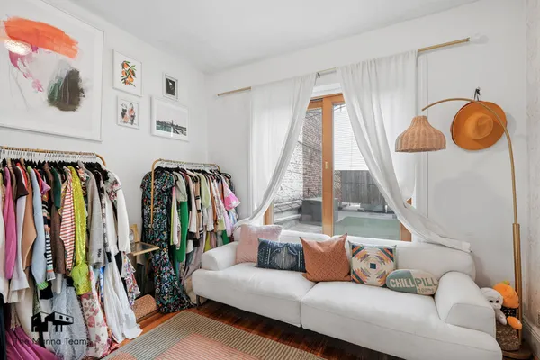 a living room with lots of baby furniture and clothes on the wall