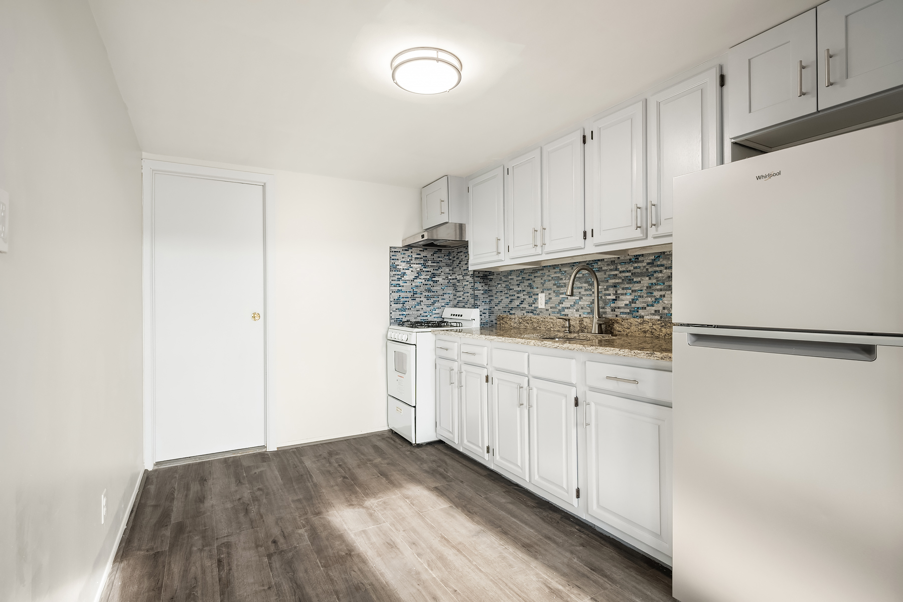 357 West 120th Street, Unit 3F Manhattan, NY 10027 - Photo 4 of 5 a kitchen with granite countertop white cabinets and refrigerator