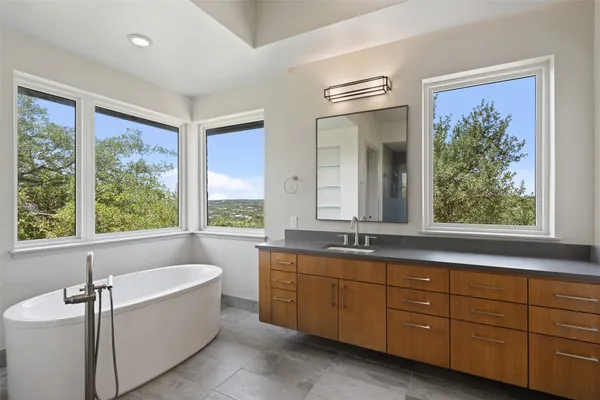 a bathroom with a bathtub sink and mirror