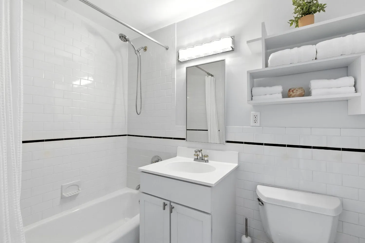 a bathroom with a sink a mirror a toilet and a shower