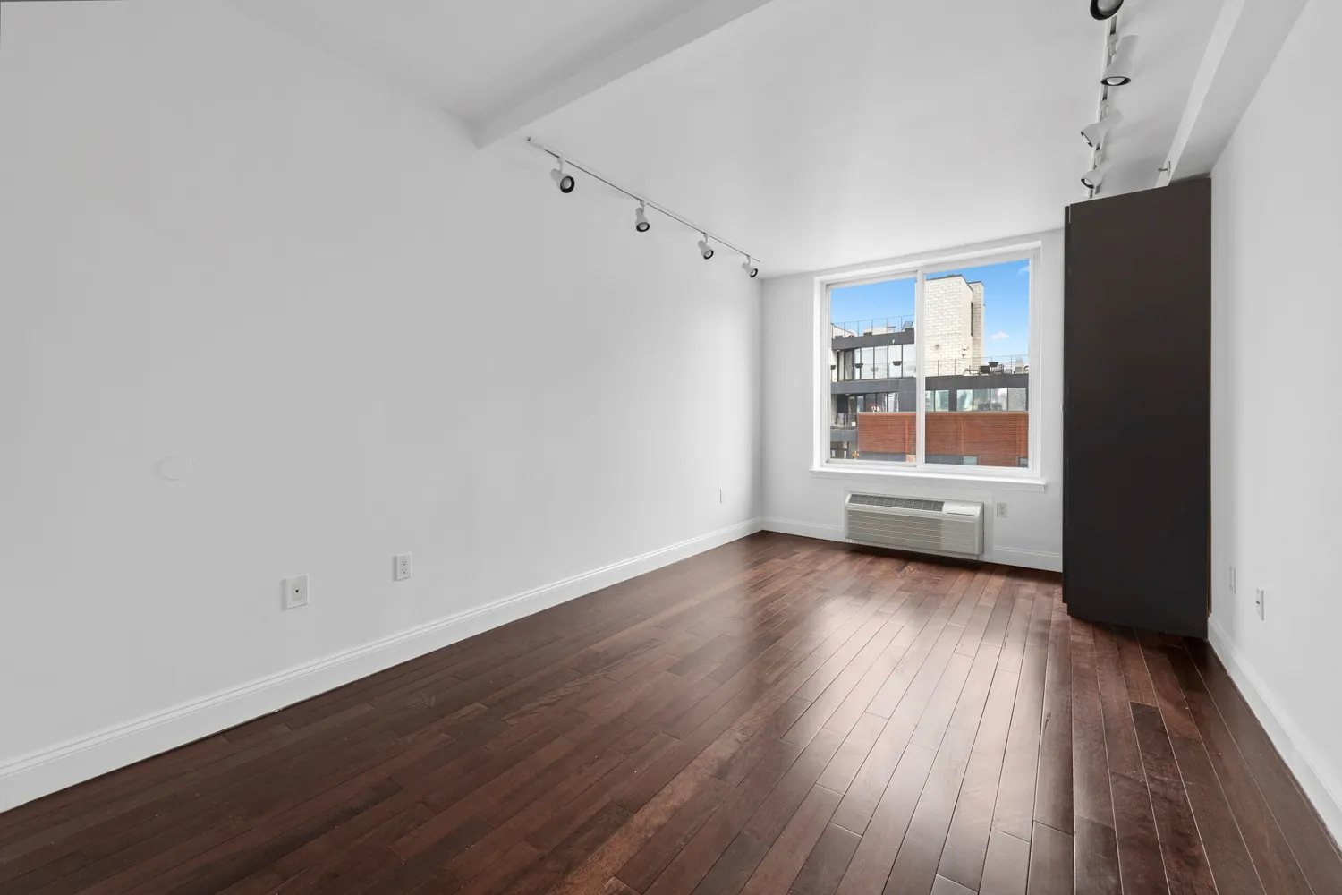 a view of a room with wooden floor and window