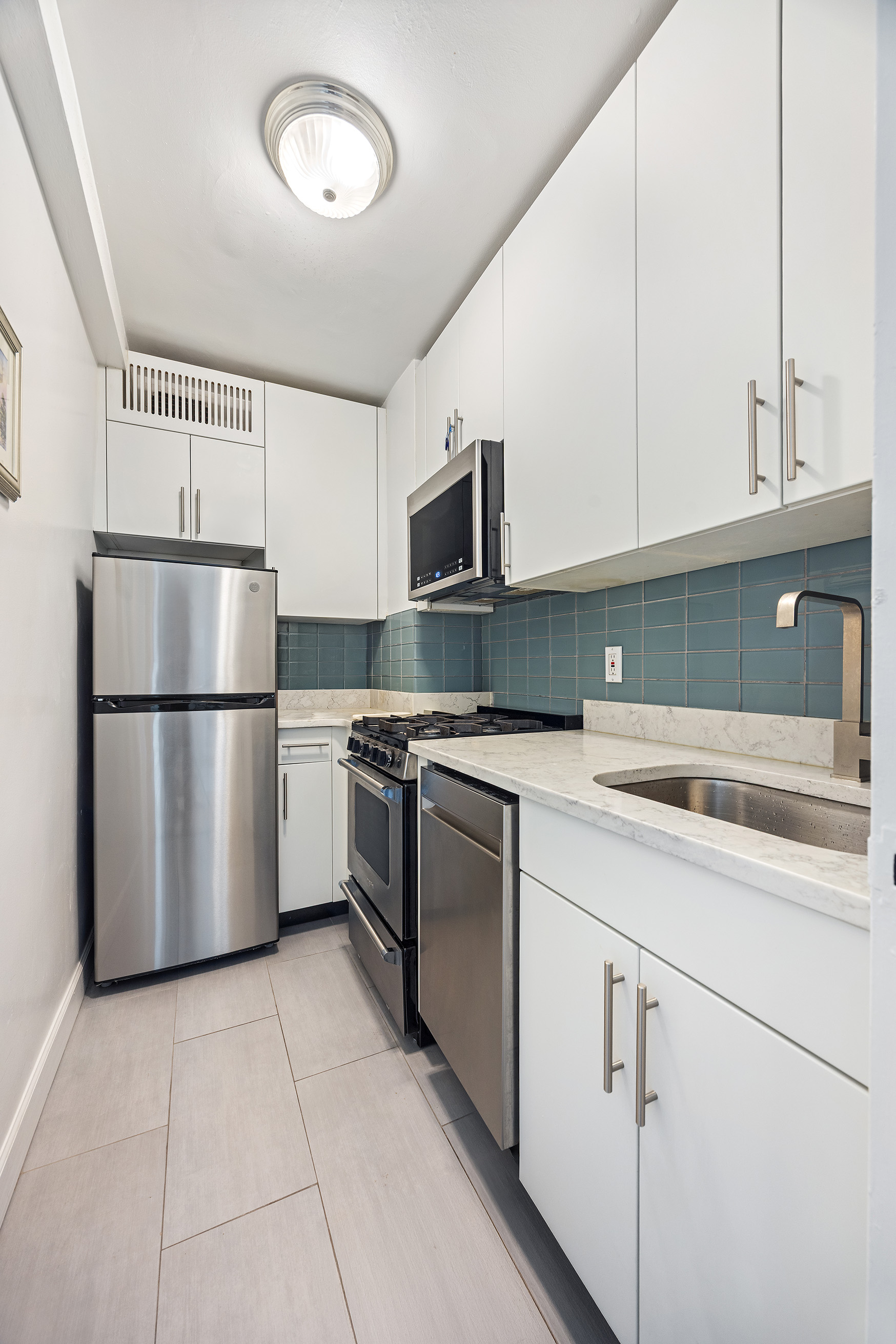 120 East 90th Street, Unit 7A Manhattan, NY 10128 - Photo 6 of 8 a kitchen with cabinets and stainless steel appliances