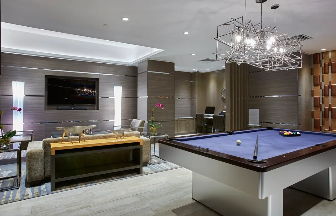 a room with pool table flat screen tv and chandelier