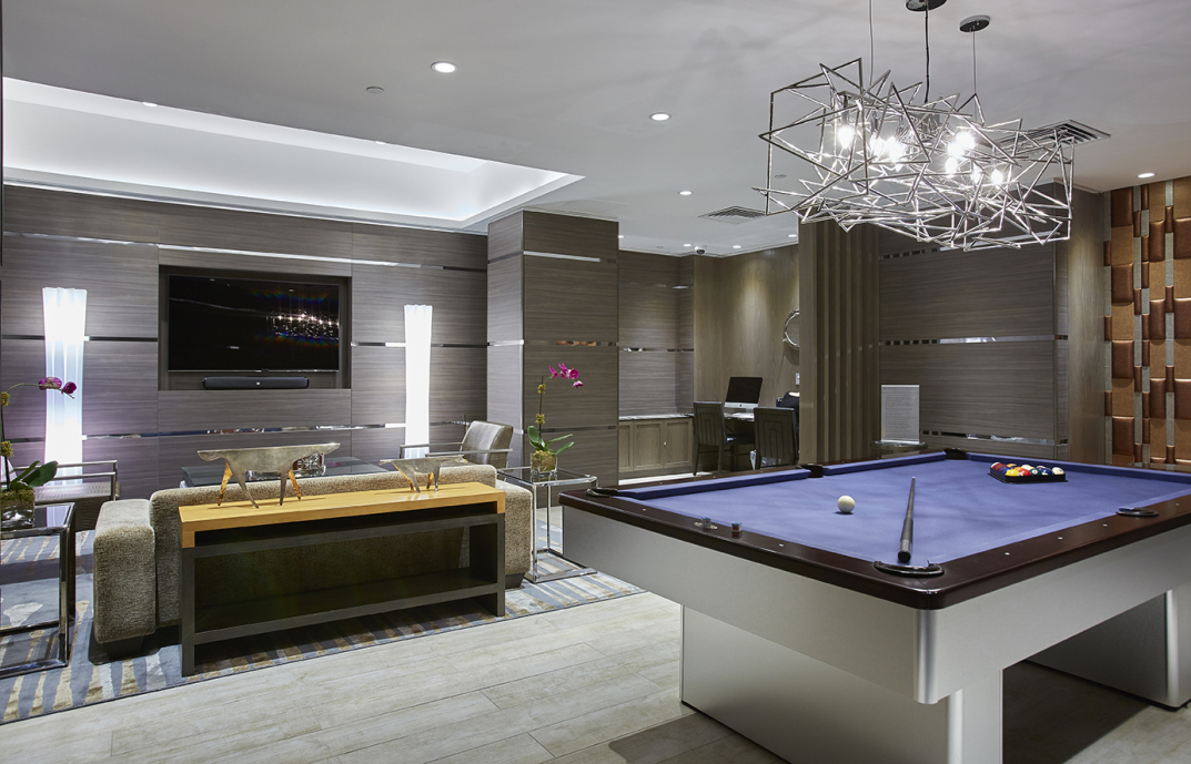 30 West Street, Unit 25G Manhattan, NY 10004 - Photo 13 of 17 a room with pool table flat screen tv and chandelier