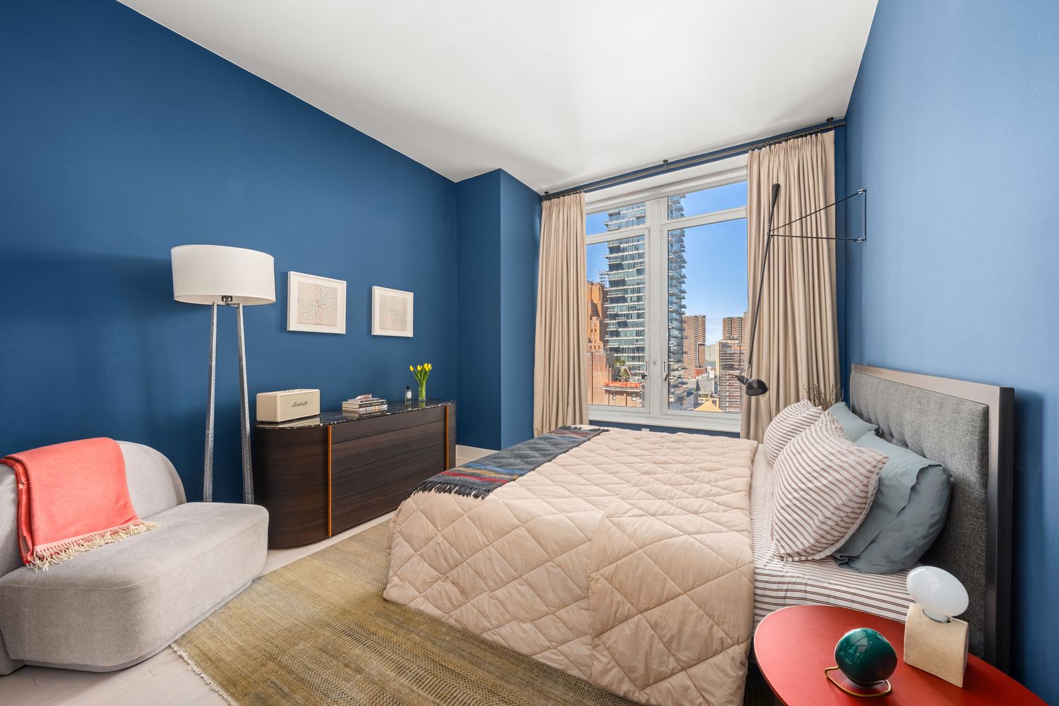 a bedroom with furniture and a large window