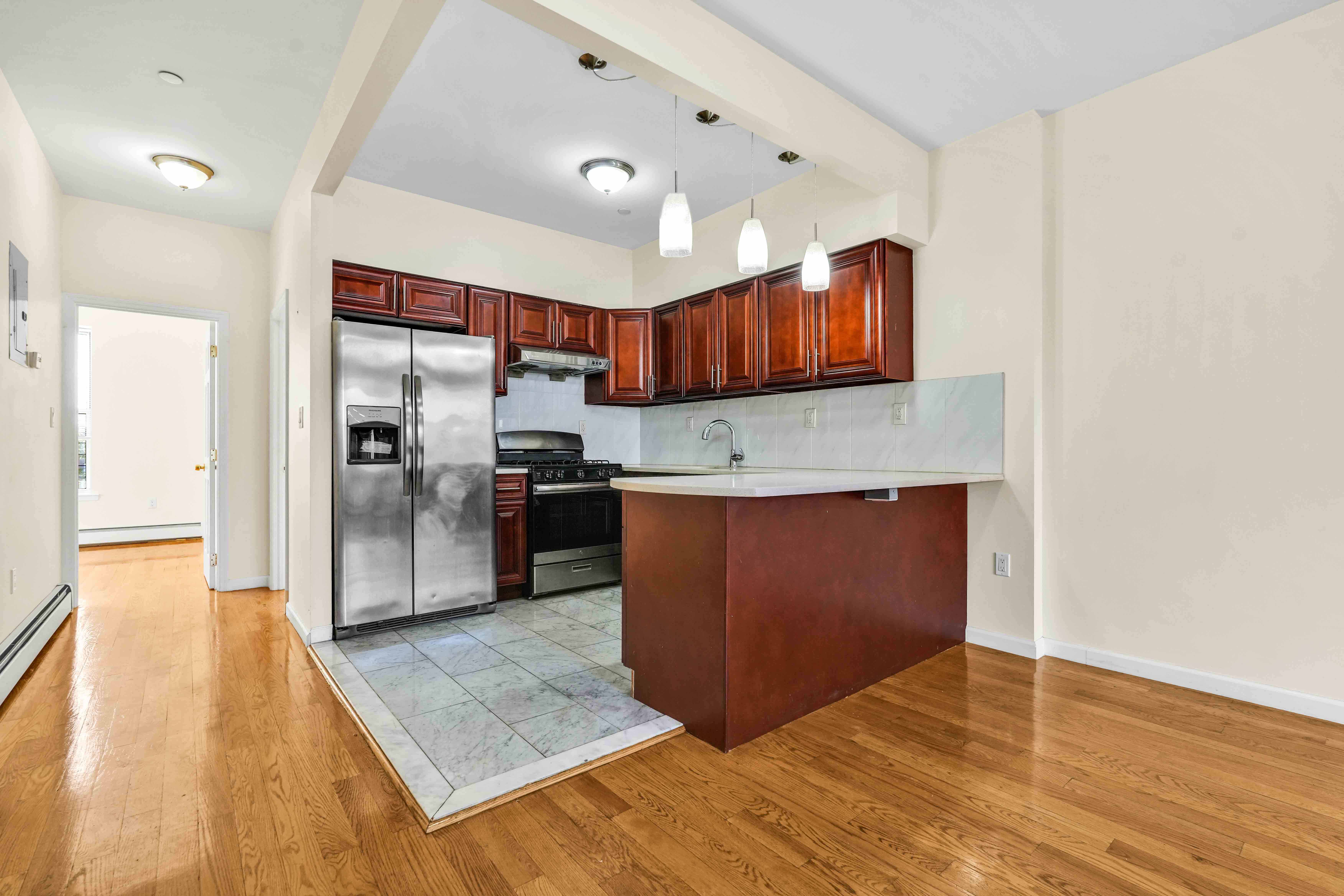 1892 Bergen Street, Unit 2 Brooklyn, NY 11233 - Photo 16 of 24 a kitchen with stainless steel appliances granite countertop a refrigerator and a sink
