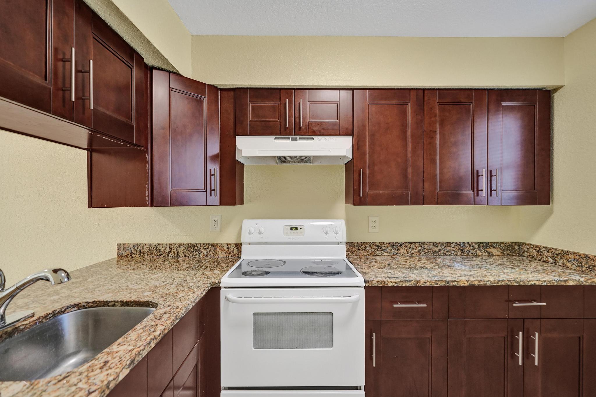 1101 Prospect Road Fort Lauderdale, FL 33309 - Photo 33 of 34 a kitchen with granite countertop wood cabinets sink and stove
