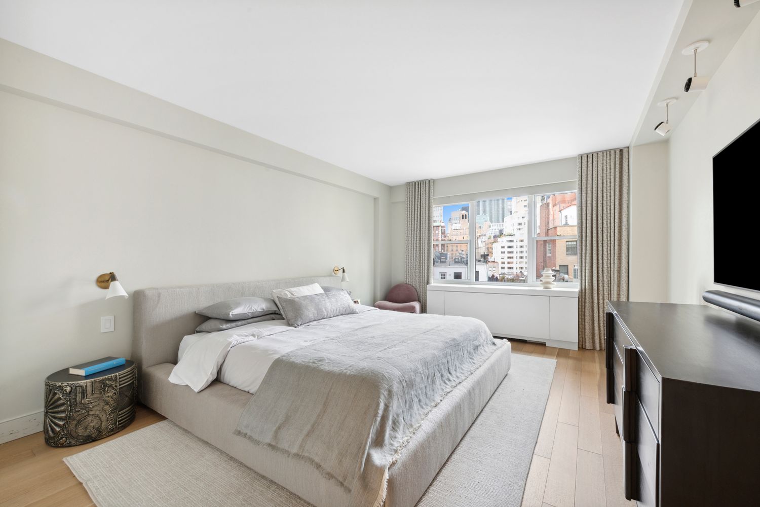 650 Park Avenue, Unit 9B Manhattan, NY 10065 - Photo 7 of 14 a bedroom with a large bed and a flat tv screen on dresser