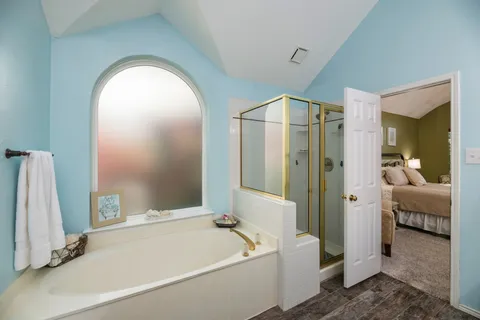 a spacious bathroom with a tub a sink and a mirror