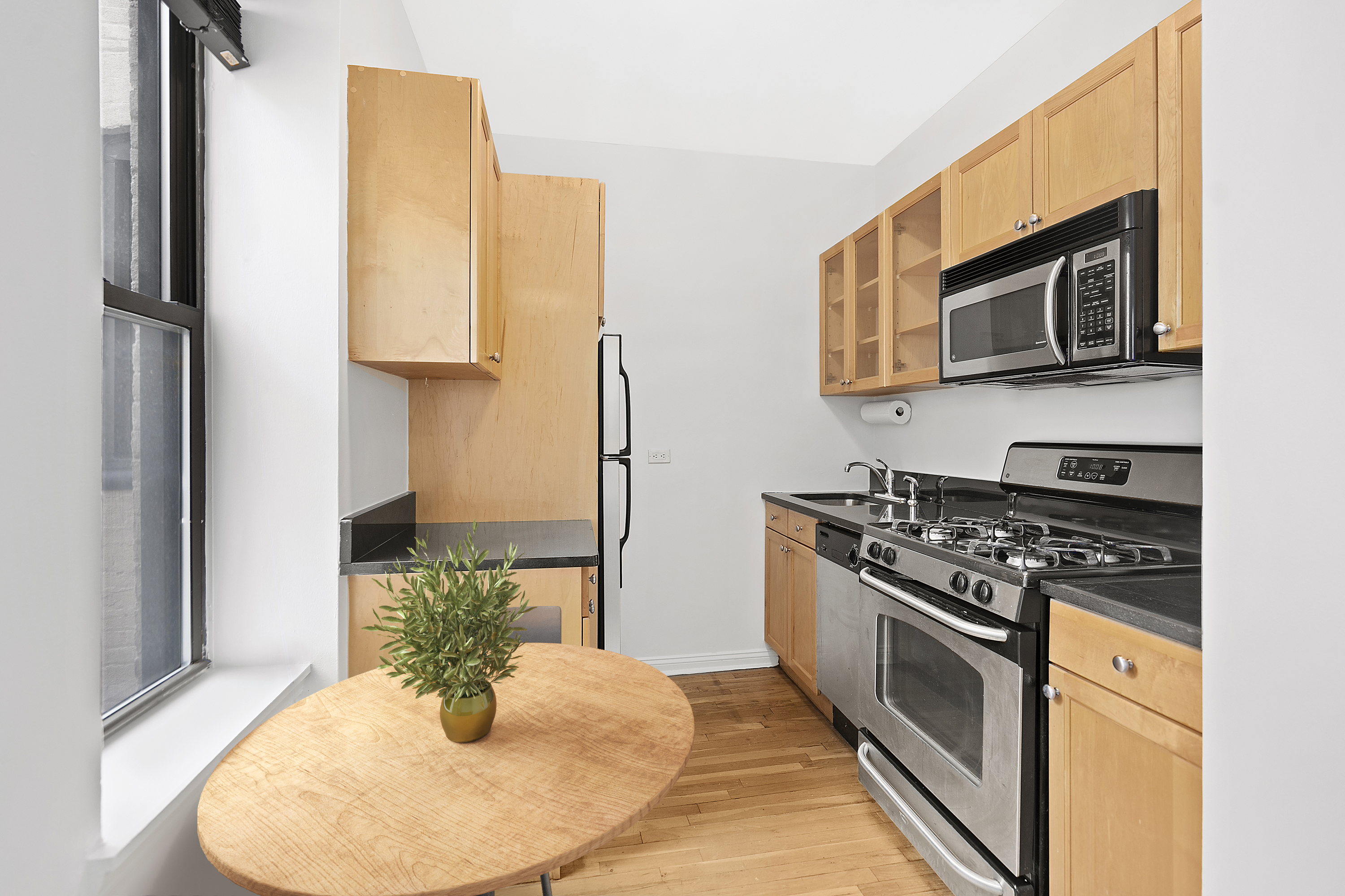 26 Butler Place, Unit 39 Brooklyn, NY 11238 - Photo 3 of 6 a kitchen with stainless steel appliances granite countertop a stove a microwave and a refrigerator