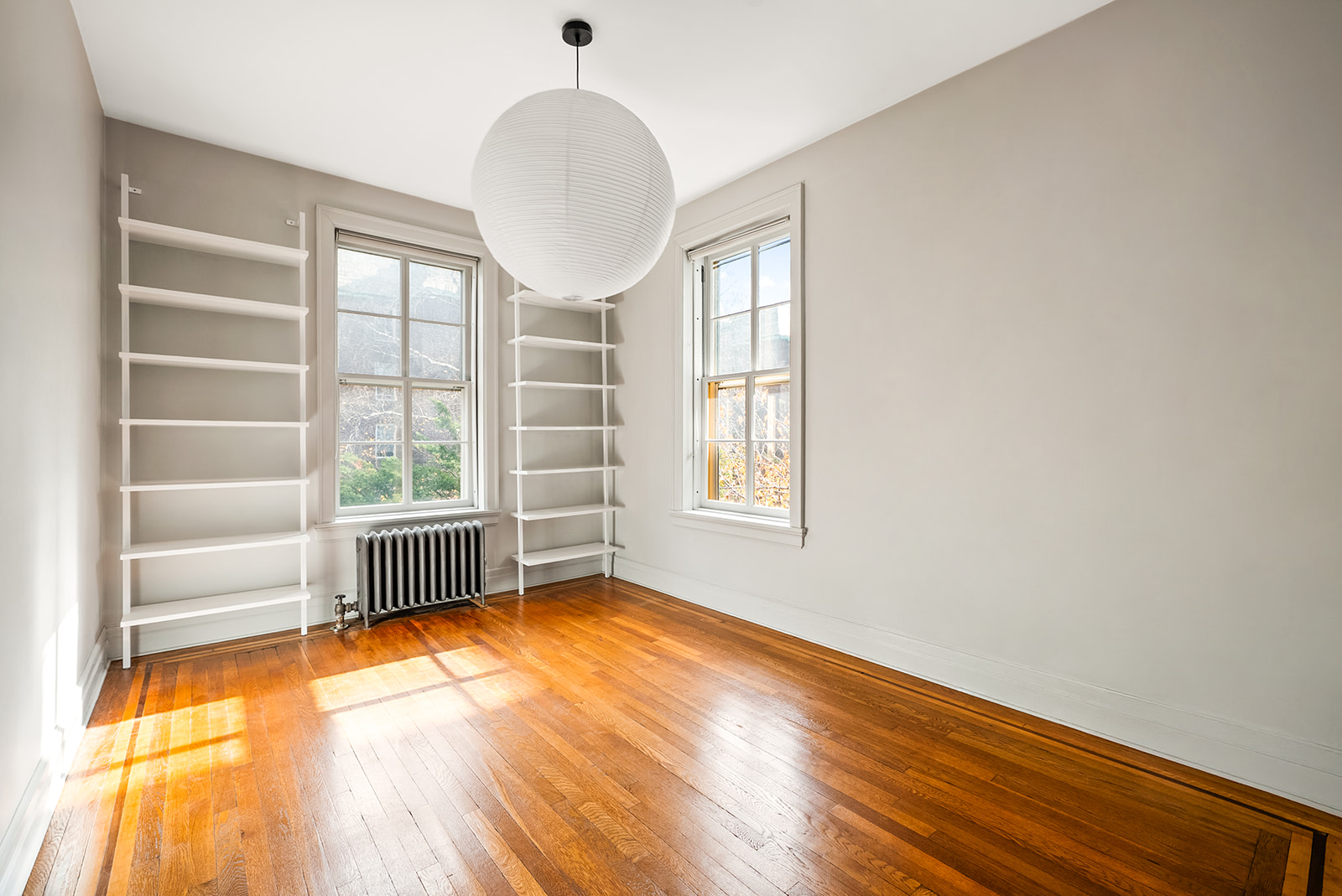 34-13 80th Street, Unit 31 Queens, NY 11372 - Photo 10 of 16 an empty room with wooden floor and windows