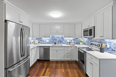 a kitchen with granite countertop stainless steel appliances a sink cabinets and a counter