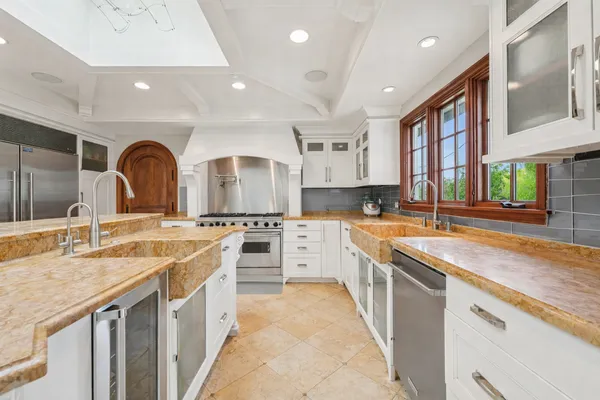 a large kitchen with stainless steel appliances granite countertop a sink and cabinets