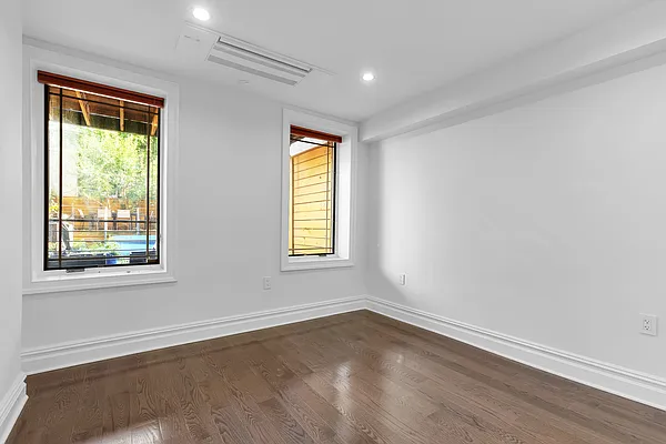 752 Jefferson Avenue, Unit GARDEN Brooklyn, NY 11221 - Photo 4 of 8 an empty room with wooden floor and windows