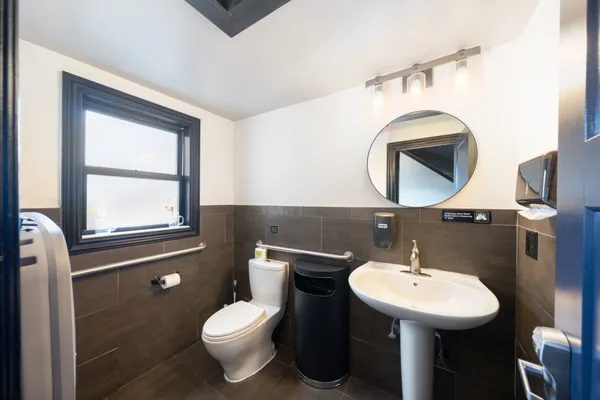 a bathroom with a toilet sink and mirror