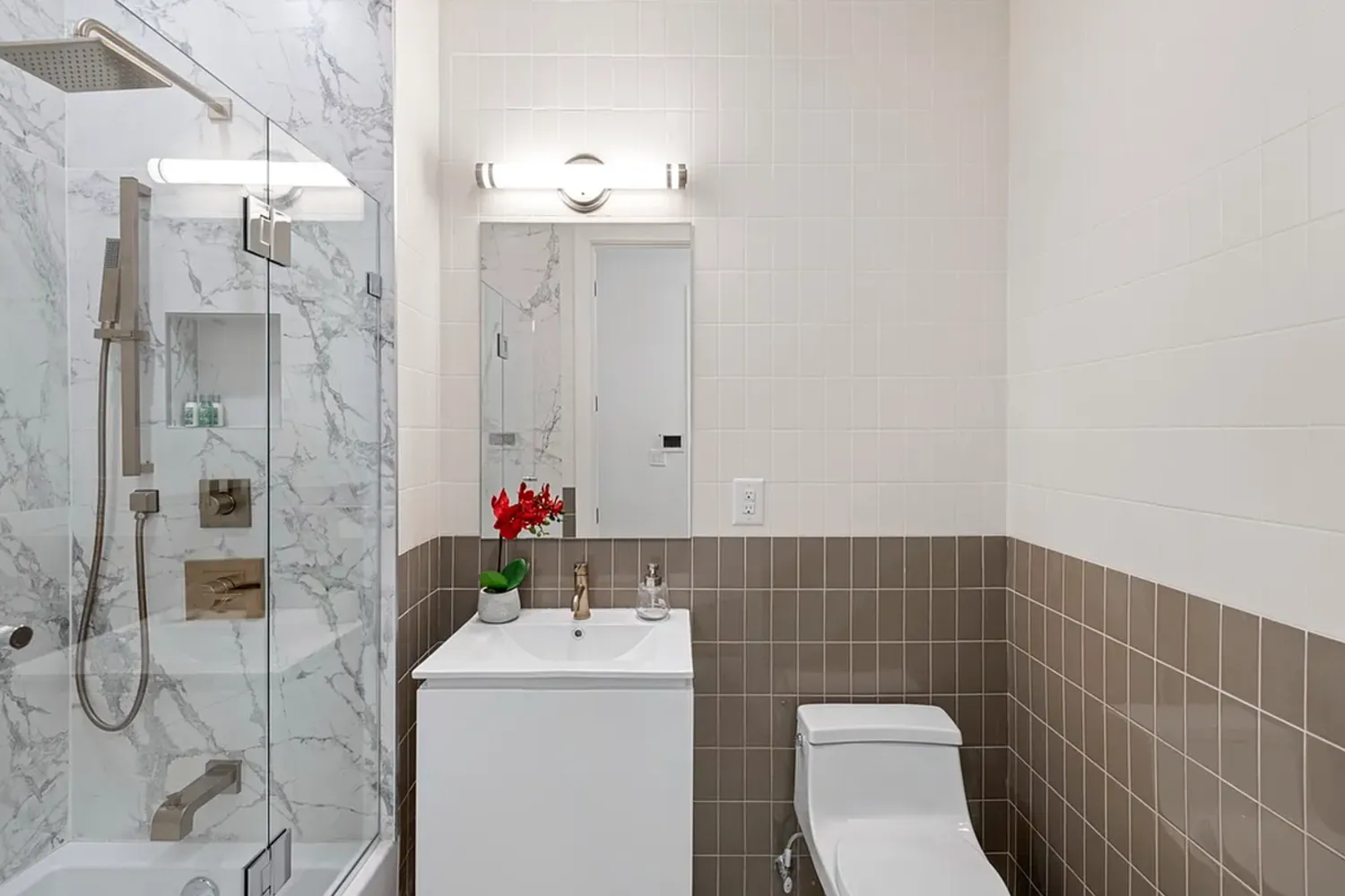 a bathroom with a sink a toilet and shower