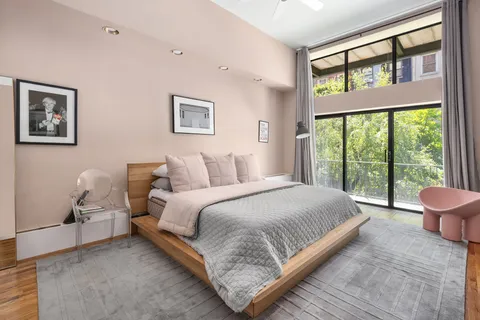 a bedroom with a bed and a large window