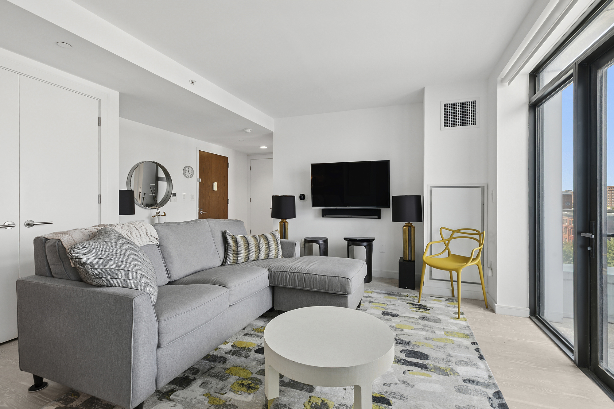 2351 Adam Clayton Powell Jr Boulevard, Unit PH23 Manhattan, NY 10030 - Photo 2 of 9 a living room with furniture and a flat screen tv