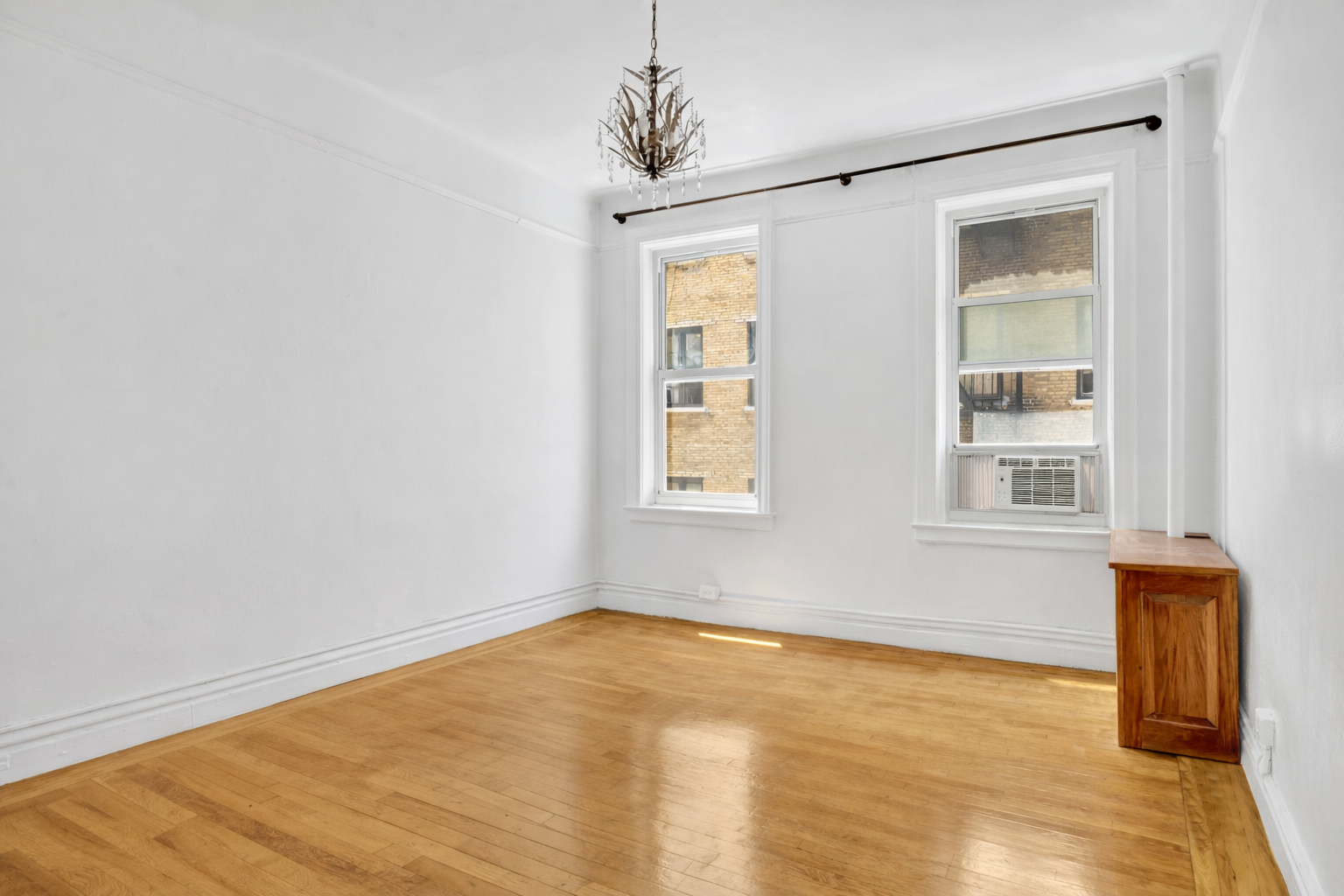 720 West 173rd Street, Unit 23 Manhattan, NY 10032 - Photo 8 of 10 a view of an empty room with wooden floor and a window