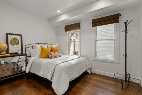 a bedroom with a bed and wooden floor