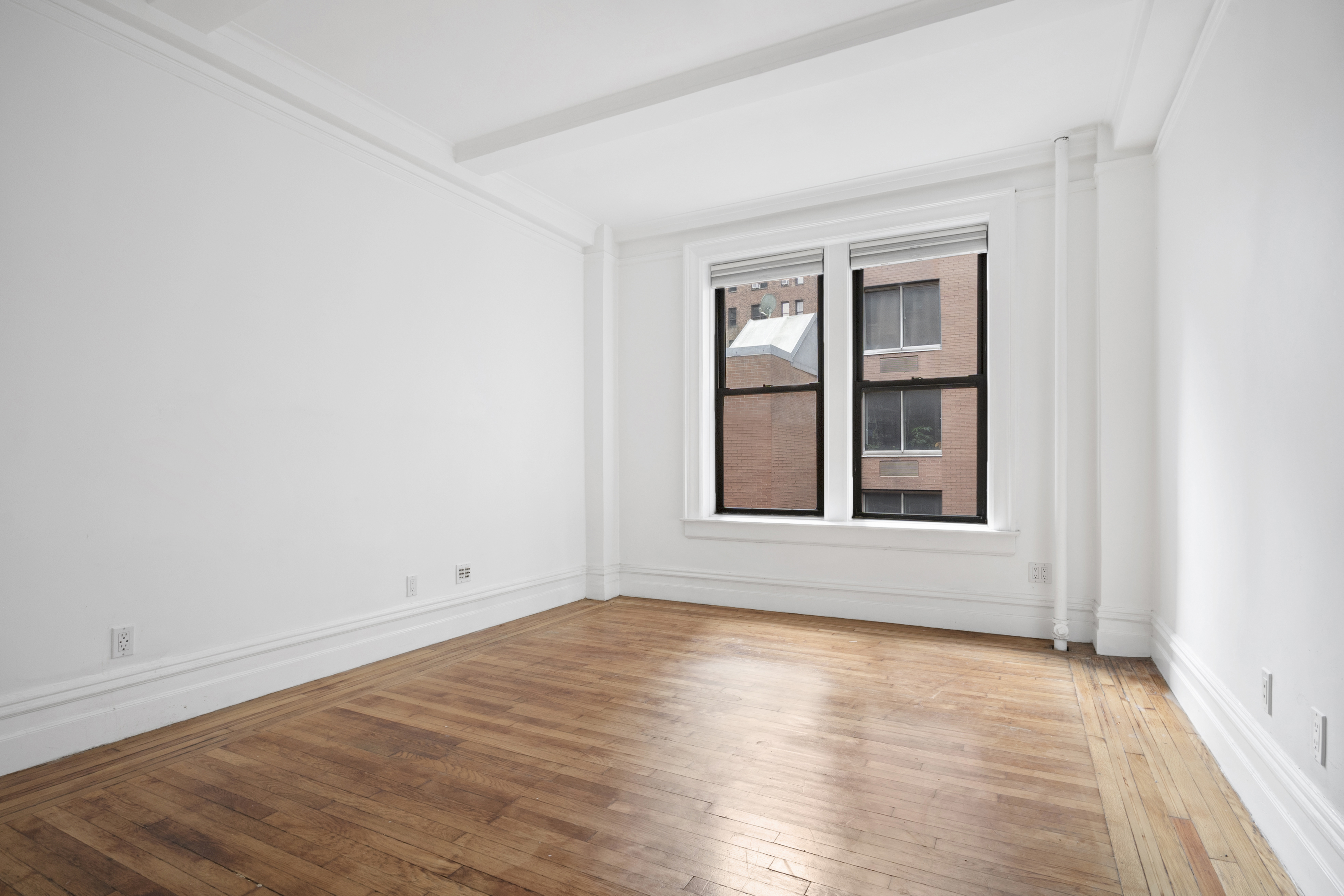 146 East 49th Street, Unit 6CD Manhattan, NY 10017 - Photo 6 of 12 an empty room with wooden floor and windows