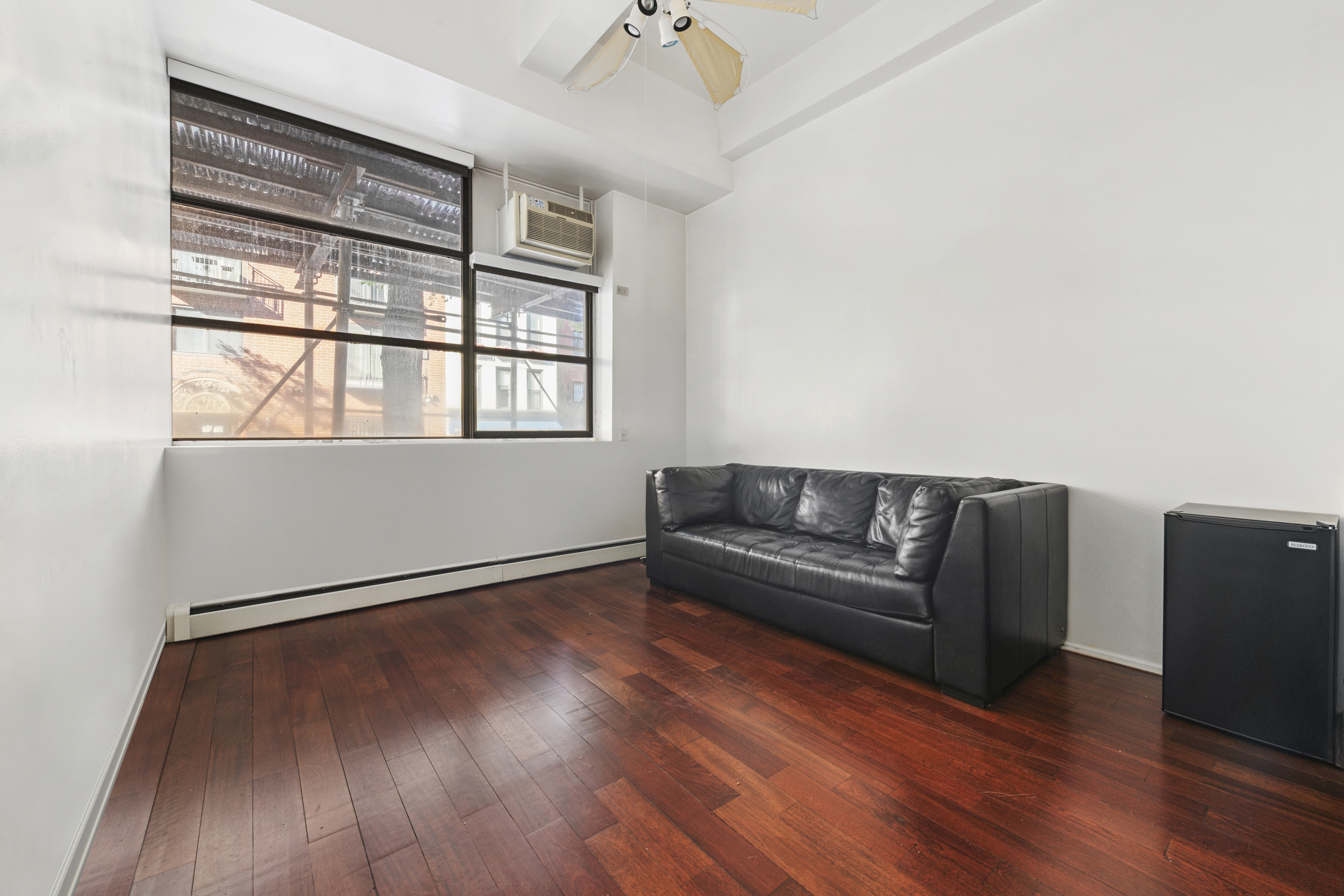 350 East 62nd Street, Unit 1N Manhattan, NY 10065 - Photo 2 of 8 a living room with wooden floor and a window