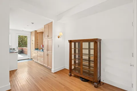 a view of a hallway with wooden floor and windows