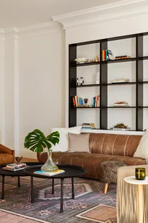 a living room with a couch and a potted plant