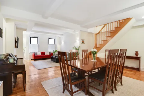 a view of a dining room and livingroom with furniture wooden floor and a rug