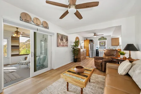 a living room with furniture a fireplace a flat screen tv and kitchen view