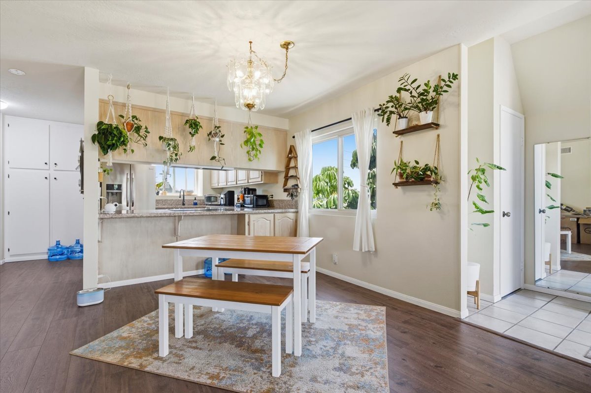 6373 Rancho Mission Road, Unit 5 San Diego, CA 92108 - Photo 9 of 30 a living room with kitchen island furniture and a chandelier