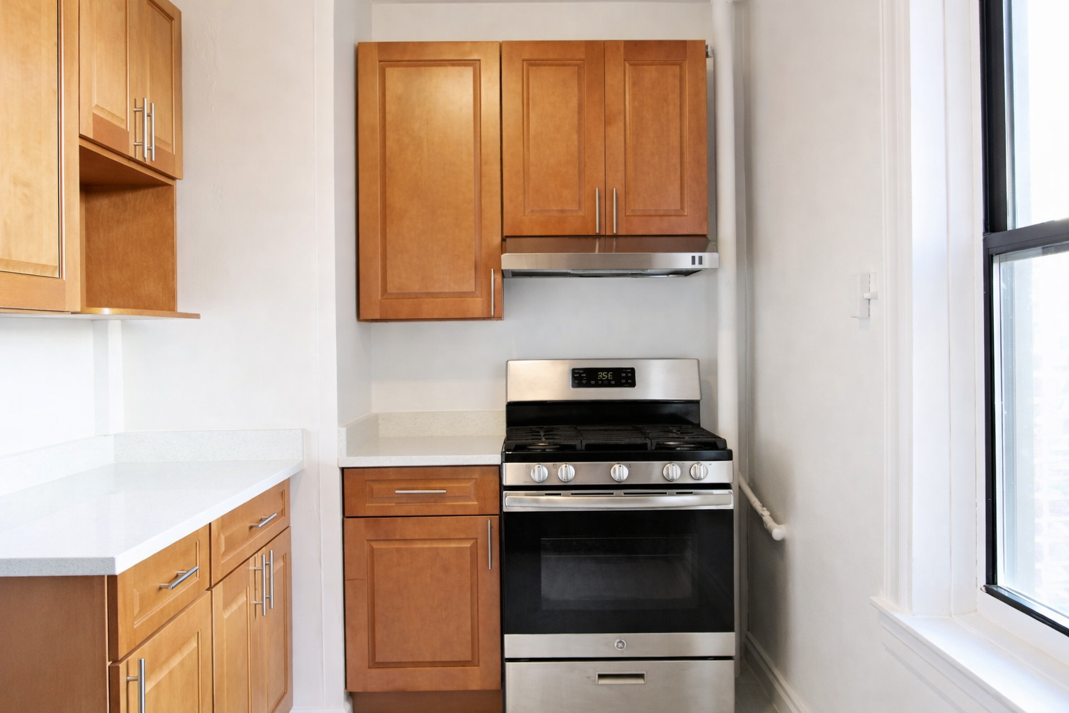 28-23 42nd Street, Unit D5 Queens, NY 11103 - Photo 2 of 10 a kitchen with stainless steel appliances a stove and a microwave