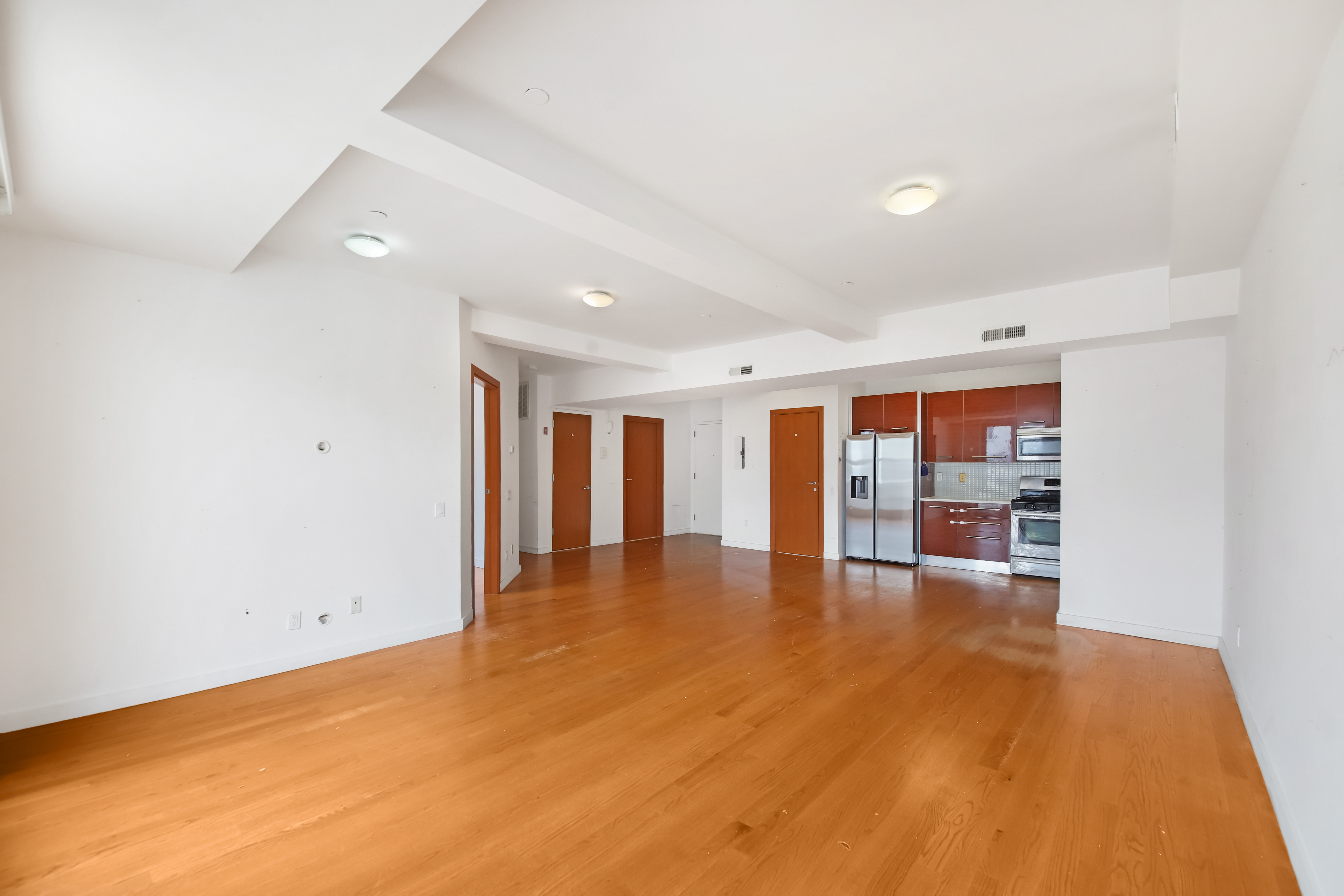 3112 Emmons Avenue, Unit 107 Brooklyn, NY 11235 - Photo 5 of 14 a view of an empty room with window and wooden floor