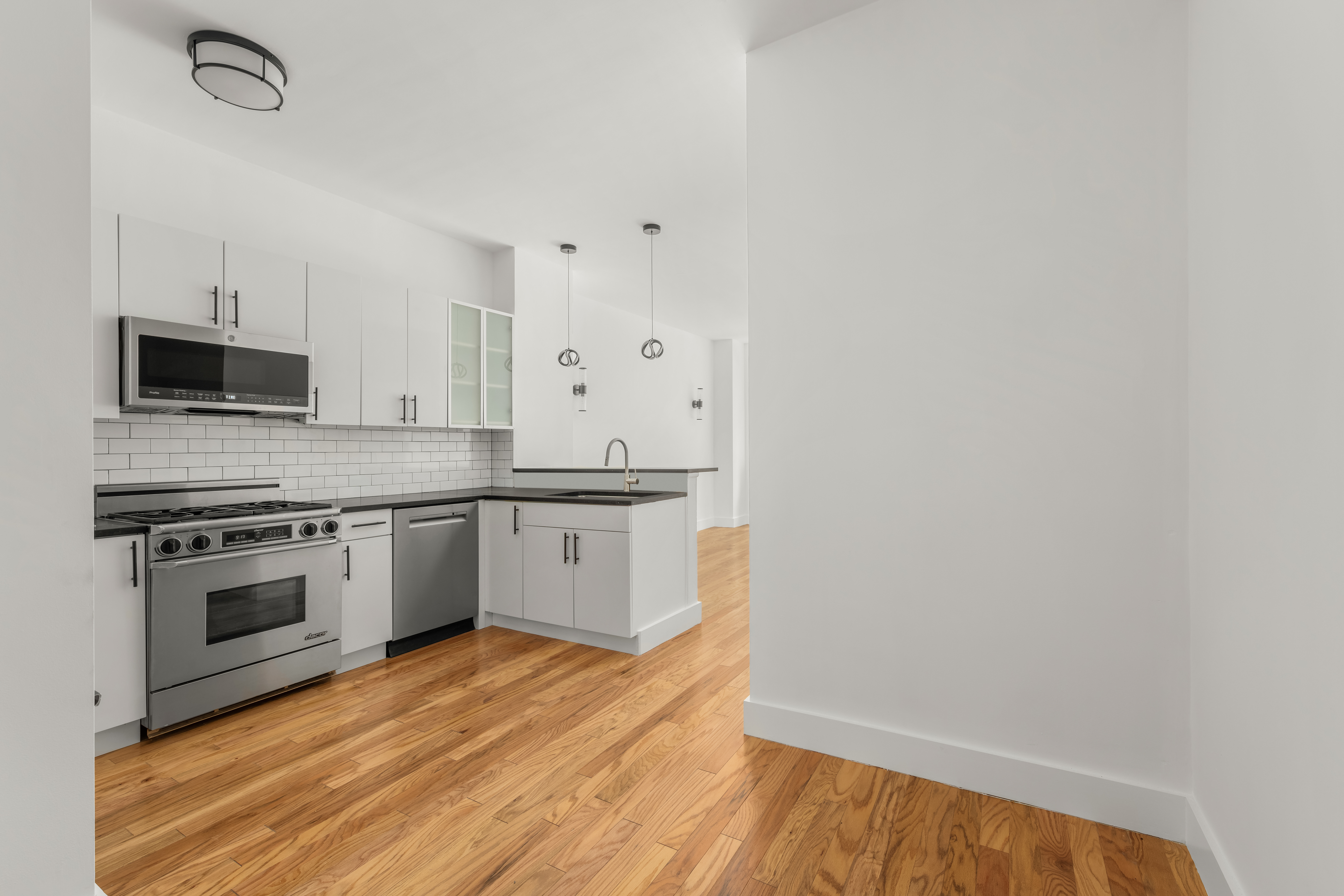 212 East 57th Street, Unit 3B Manhattan, NY 10022 - Photo 2 of 17 a kitchen with granite countertop white cabinets and stainless steel appliances