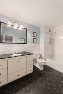 a bathroom with a granite countertop sink mirror vanity and toilet