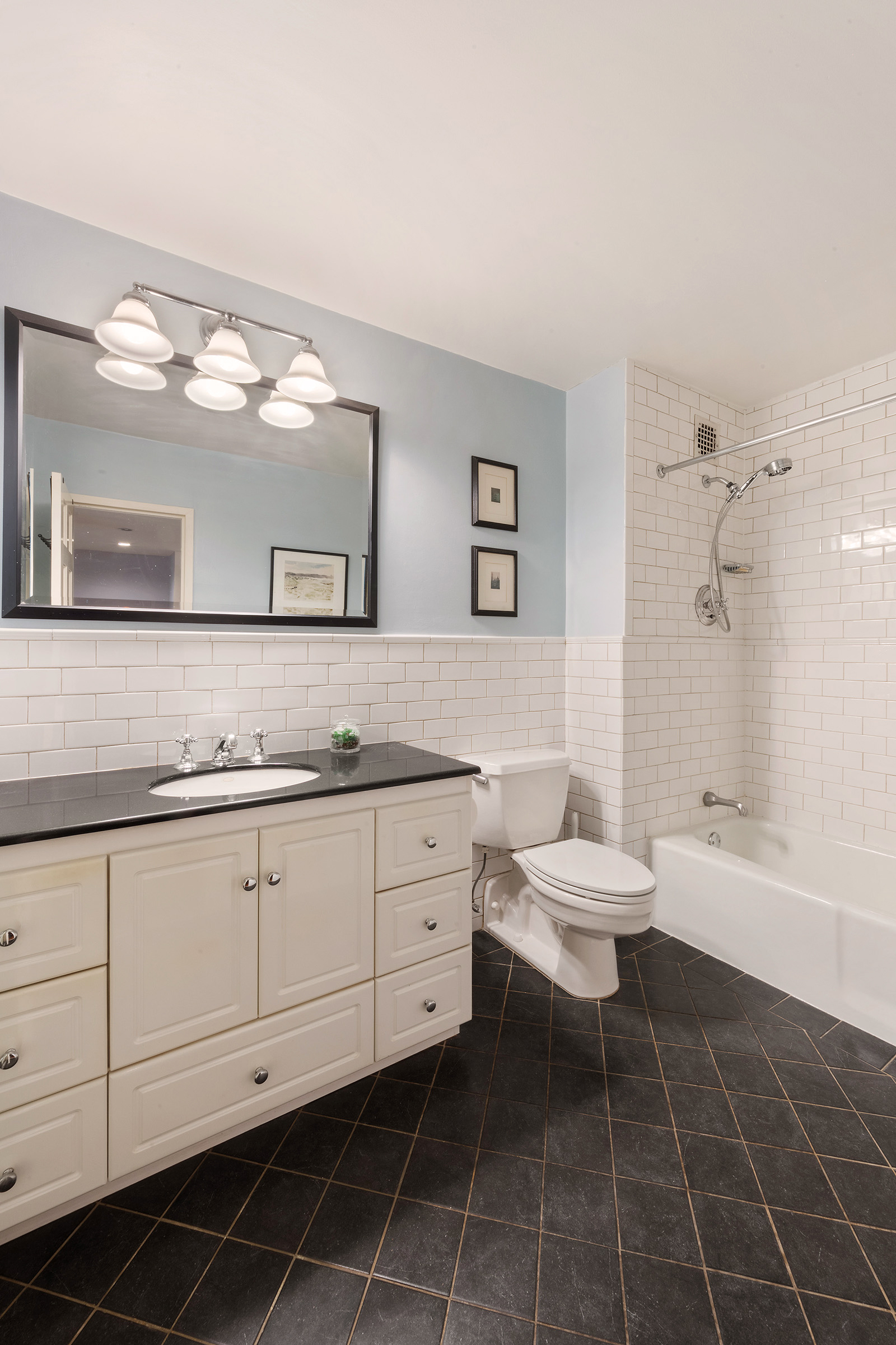 161 West 15th Street, Unit 2D Manhattan, NY 10011 - Photo 5 of 10 a bathroom with a granite countertop sink mirror vanity and toilet